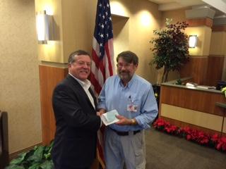 Doug Ottinger accepts a check from Larry Sharp